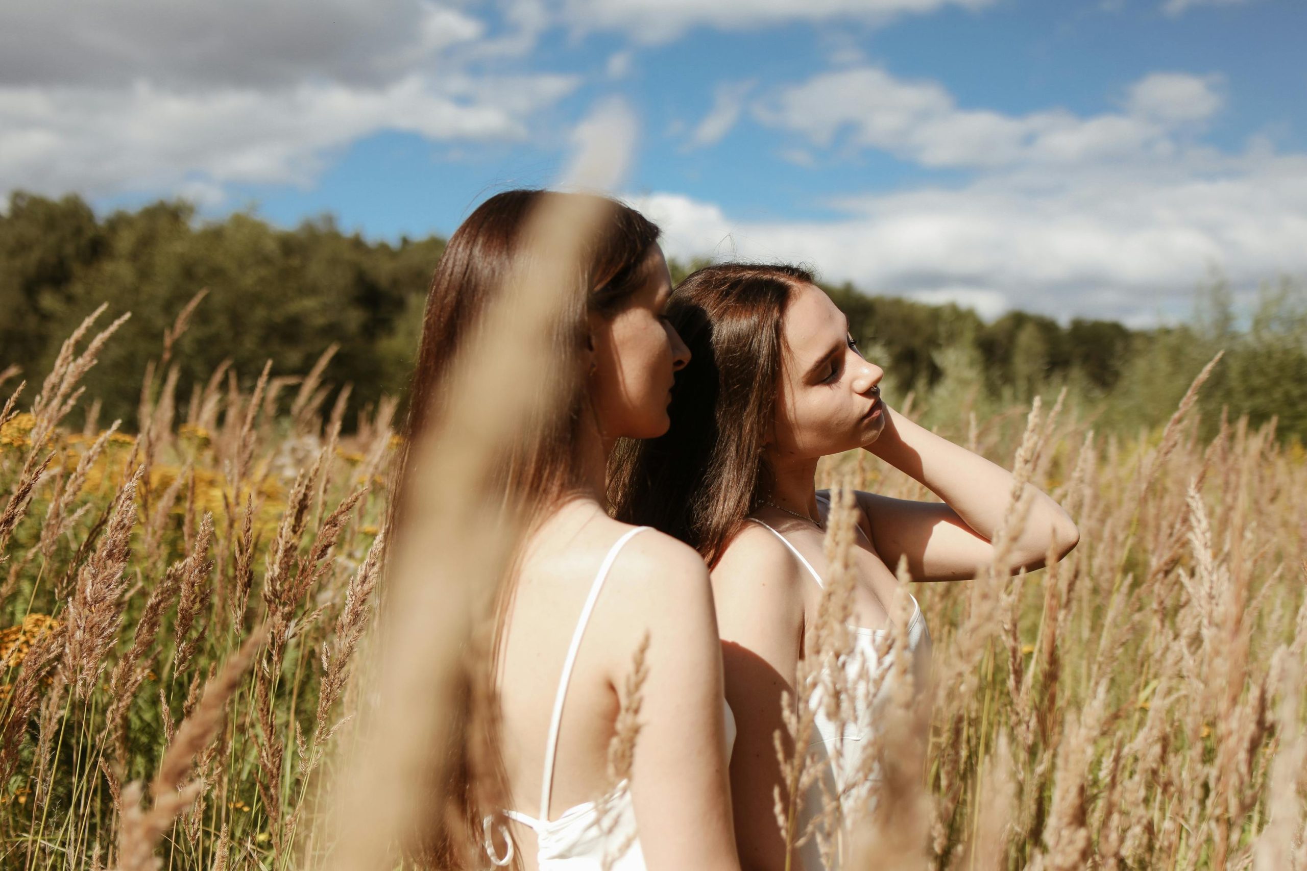 Dos personas caminando juntas en un campo abierto, en actitud tranquila y consciente, simbolizando autocuidado profundo, descanso emocional y conexión con el cuerpo.