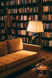 Rincón tranquilo con sofá y libros que invitan a la reflexión y al autoconocimiento.